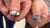 Two silver rings with gemstones held between fingers against a blurred background